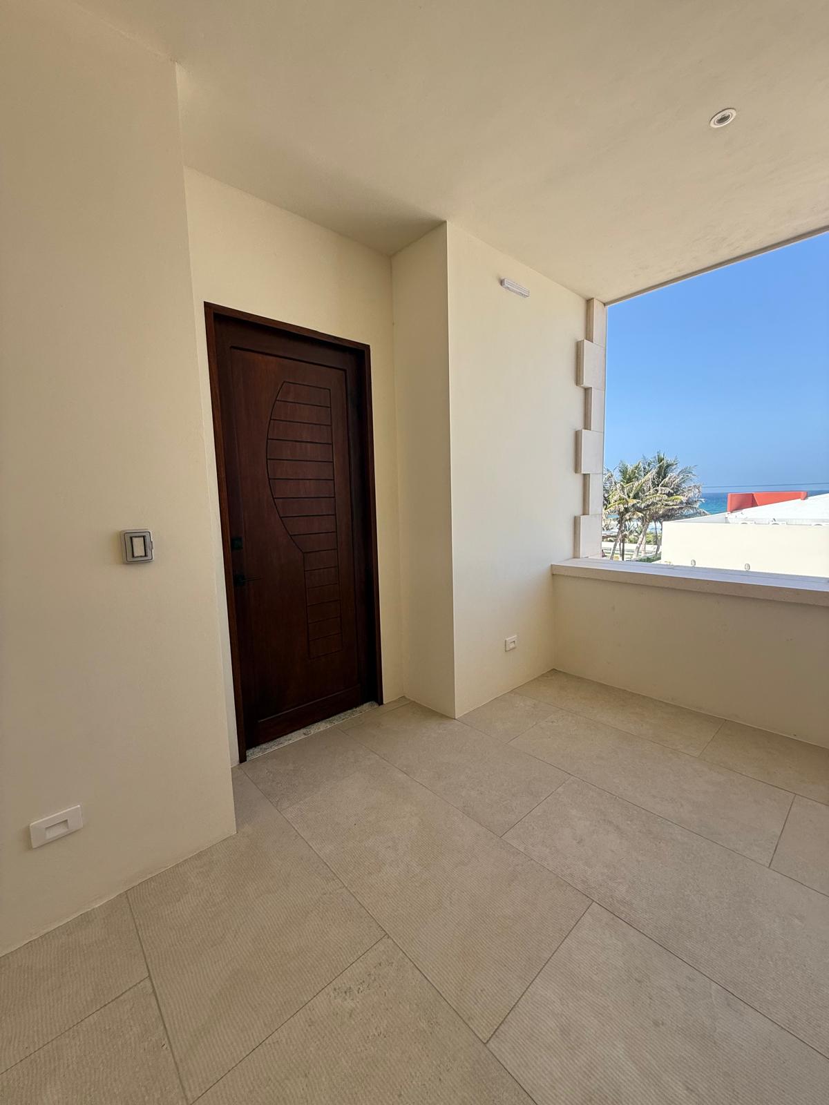 Suite entry with carved wood door and ocean-view window