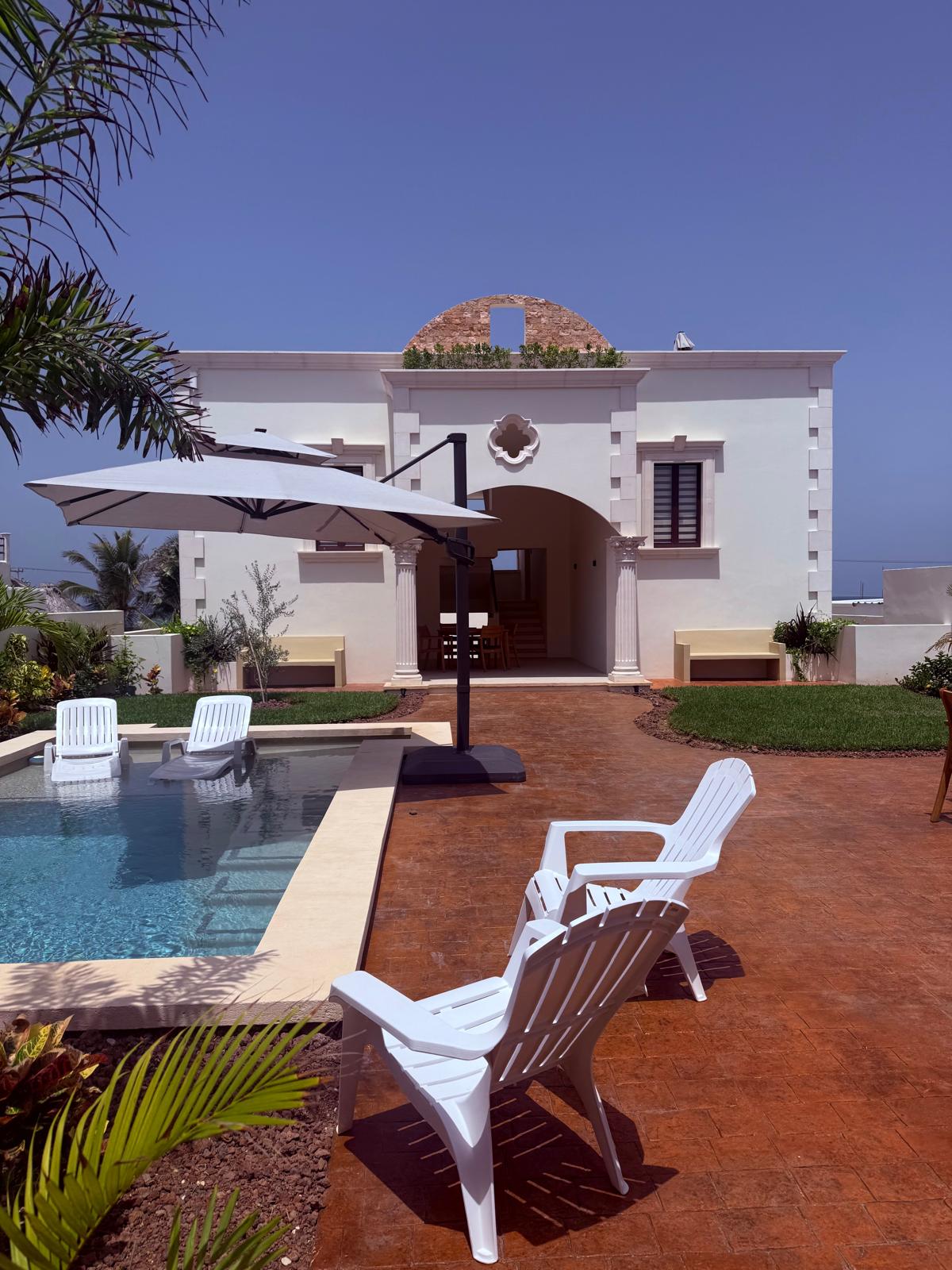 Casa Pasqualina facade and courtyard pool in midday sun