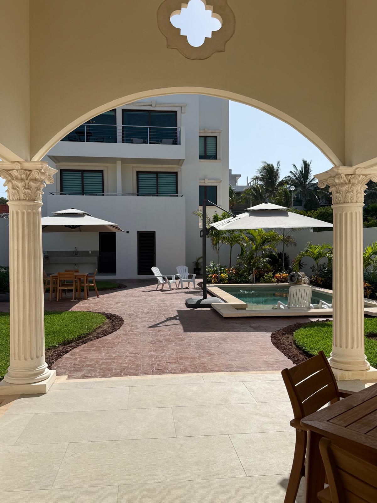 Arched loggia view across the courtyard to the pool