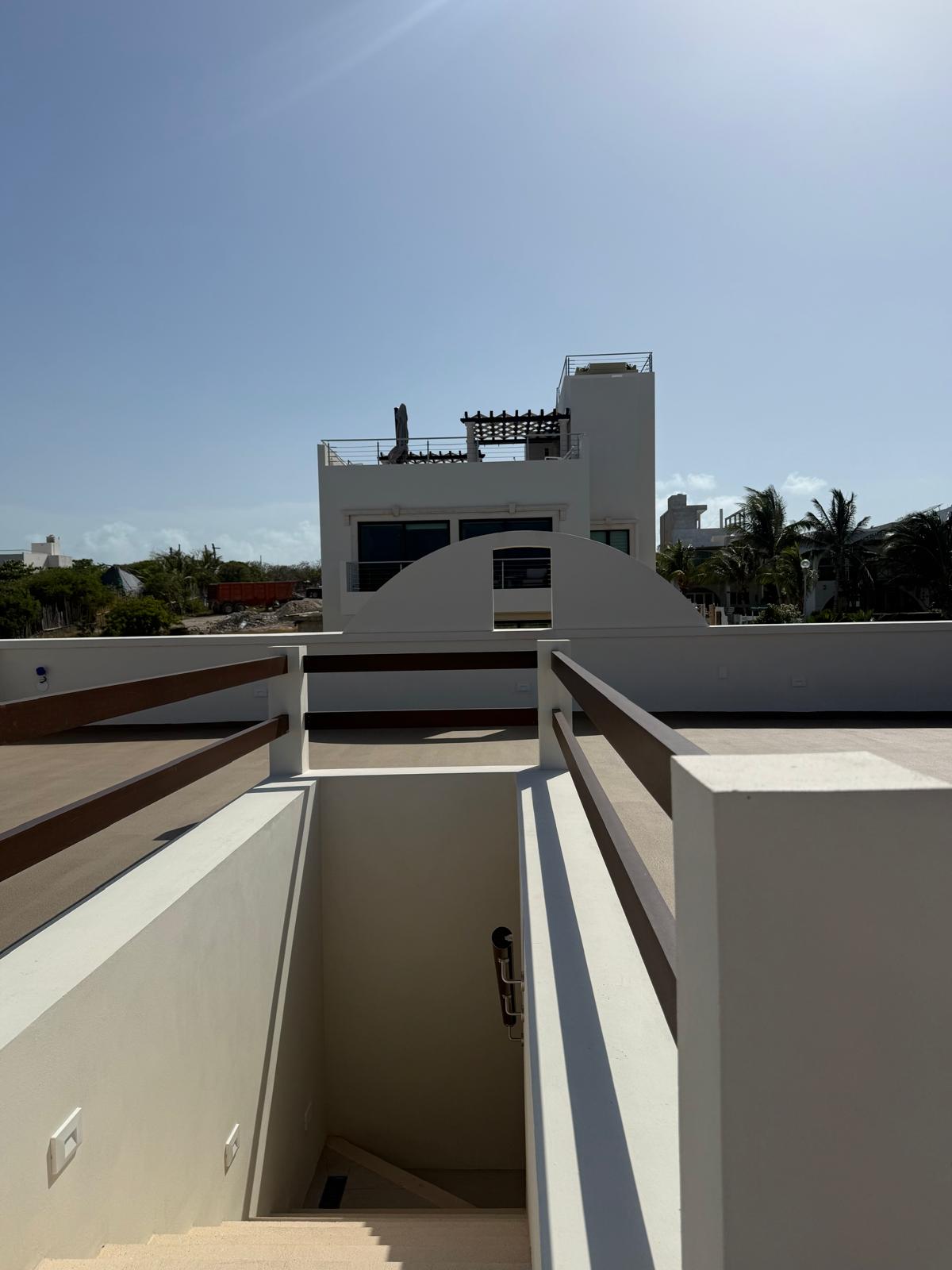 Rooftop terrace stair access with pergola and island views