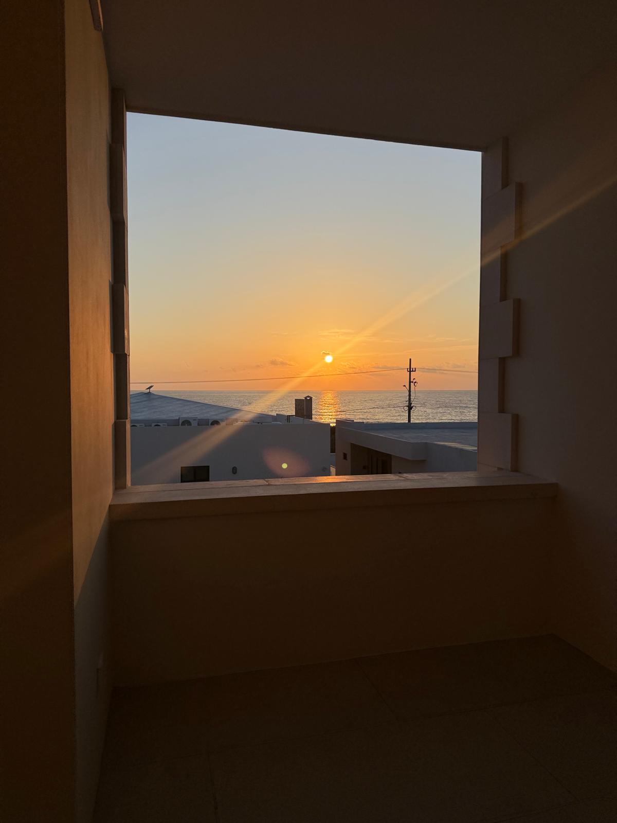 Sunrise framed by a deep stone window opening