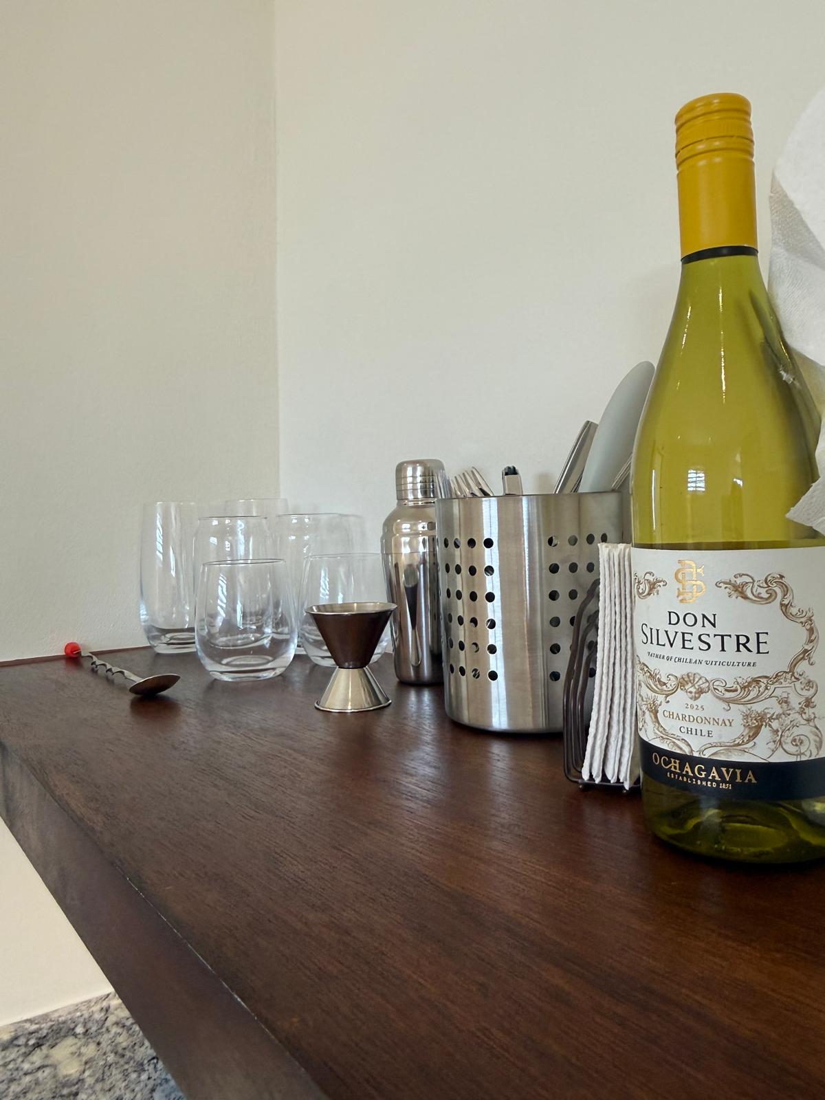 Suite bar shelf with glassware, shaker, jigger, and wine