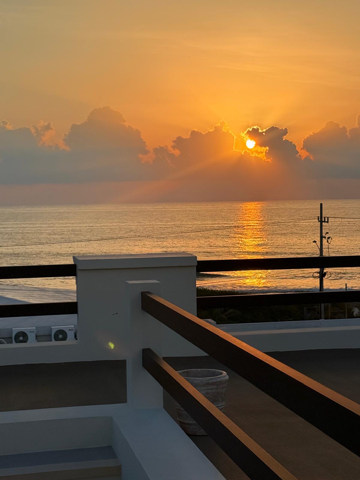 Sun breaking through clouds over the sea from the rooftop