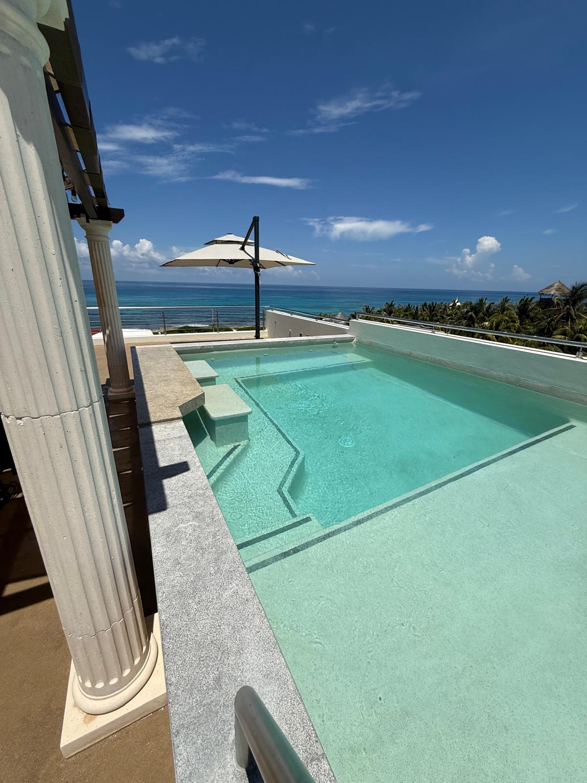 Rooftop pool with umbrella and ocean view