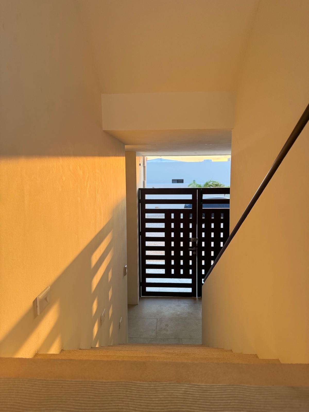 Stairway down to the slatted wood entry gate
