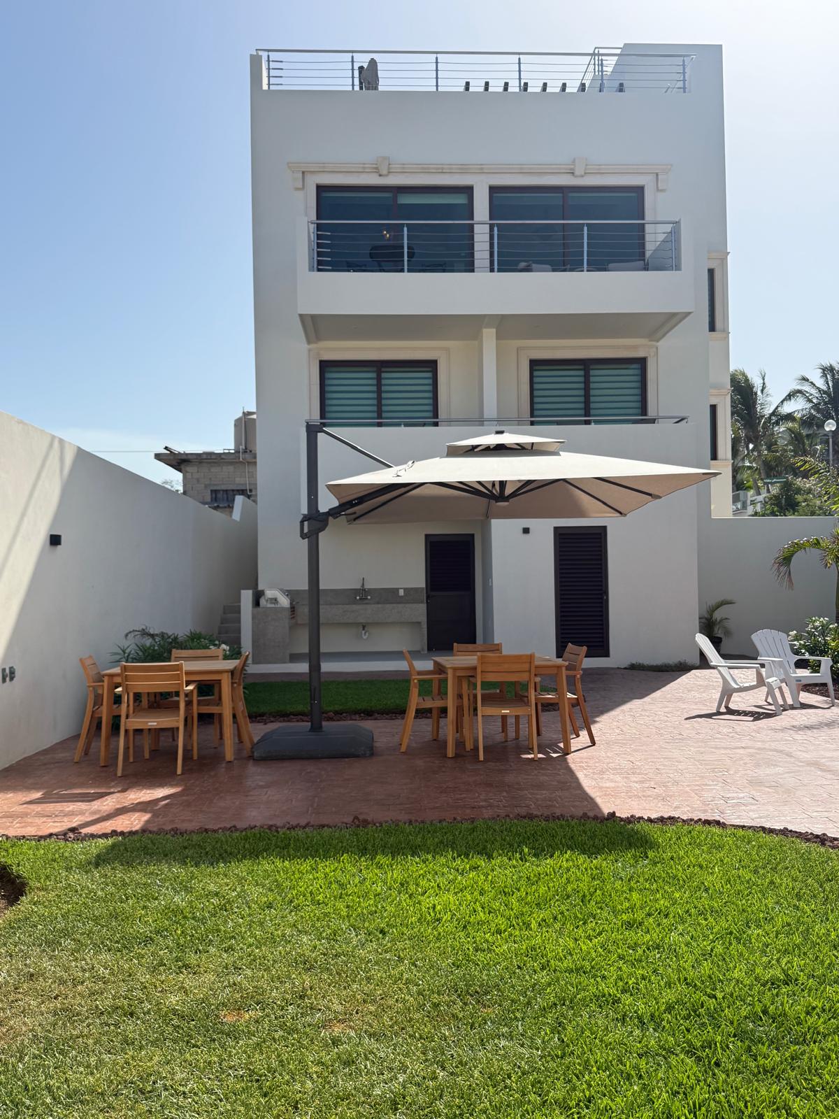 Casa Isola Suites exterior with shaded courtyard dining