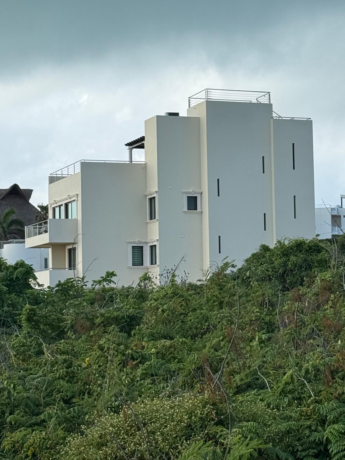 Casa Pasqualina's multi-level white exterior rising above the island greenery