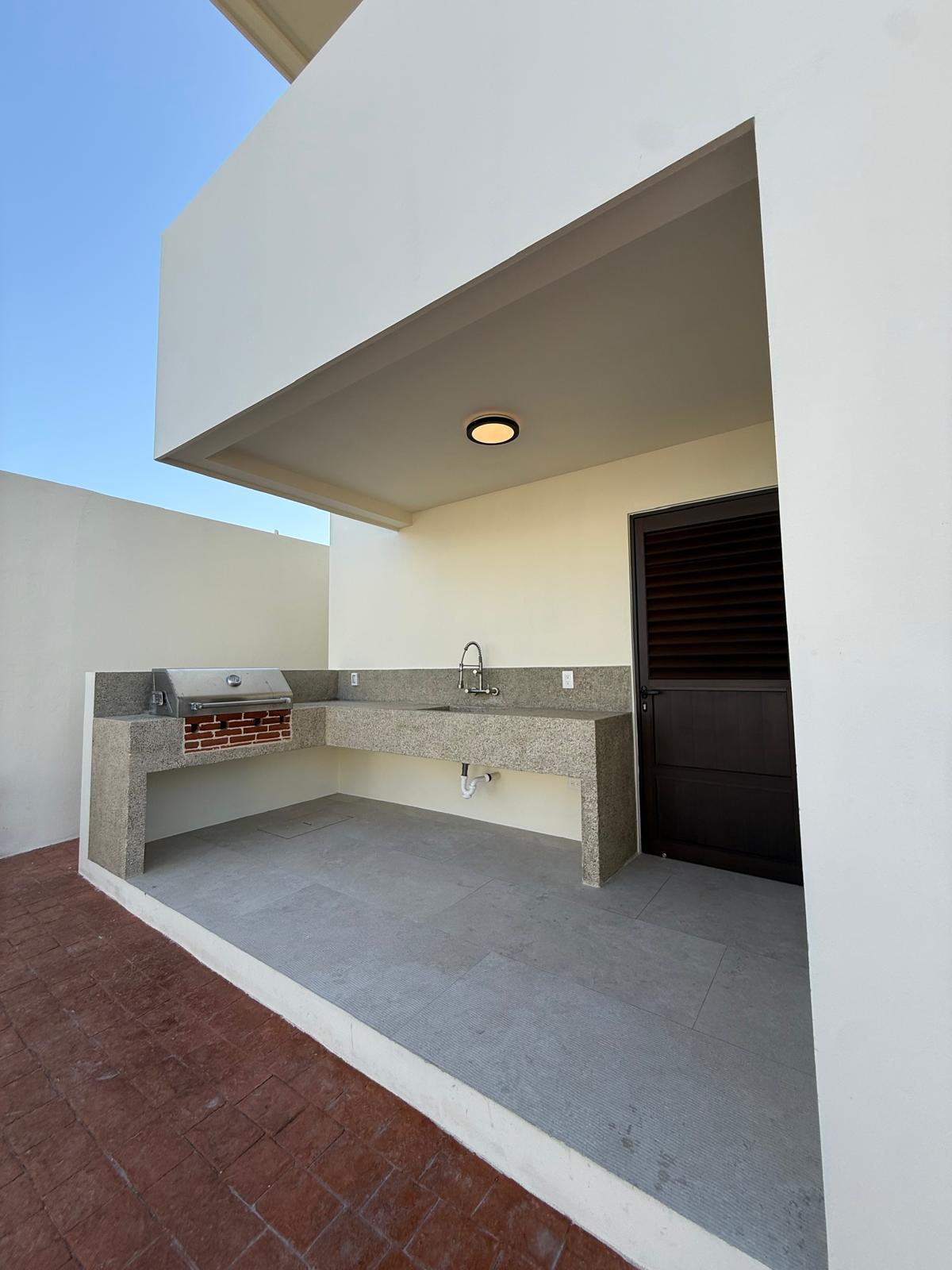 Covered outdoor kitchen with grill and granite counter