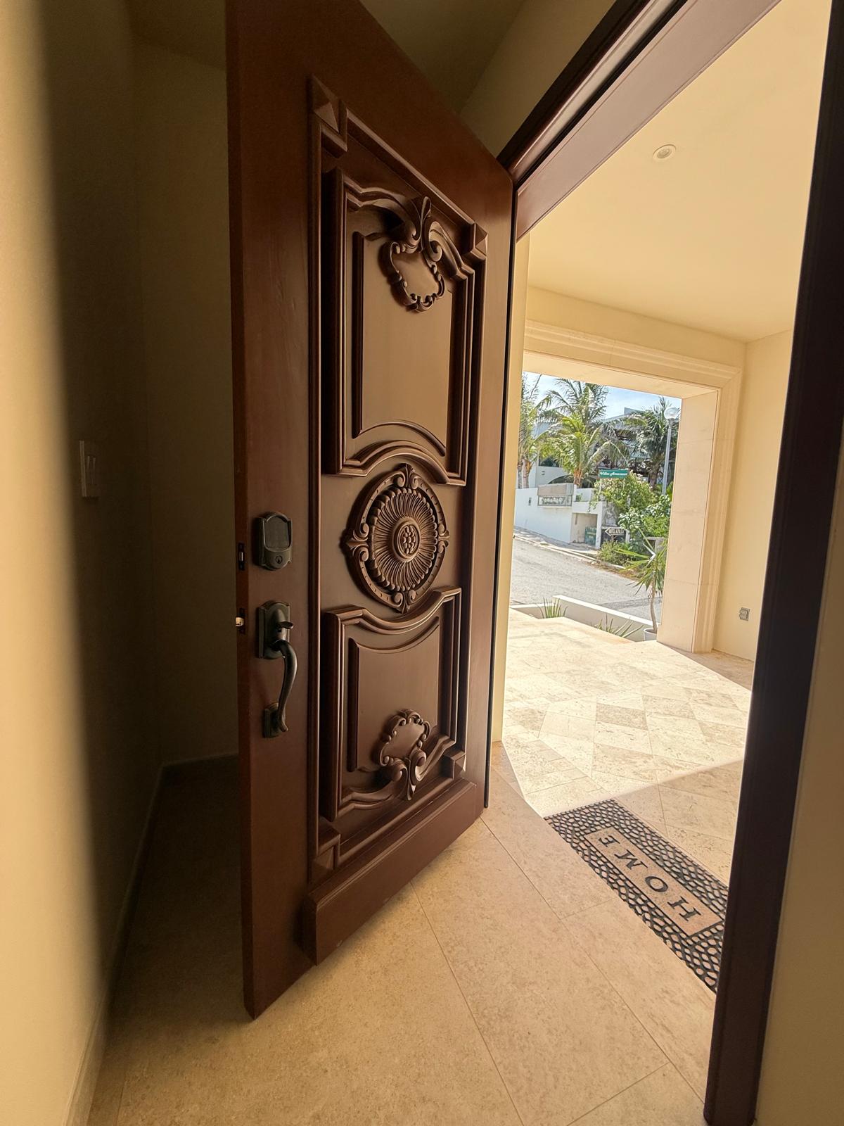 Hand-carved wooden entry door opening to the courtyard