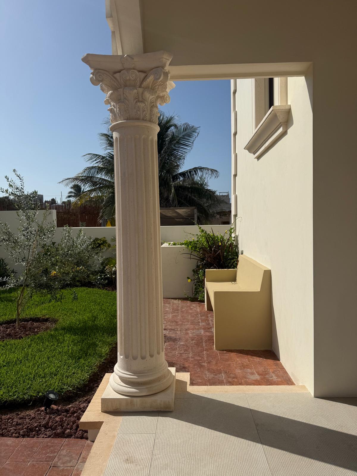 Carved Corinthian column beside the garden lawn