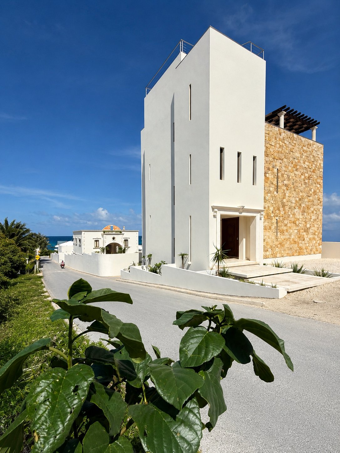 White tower facade of the estate above the road to the Caribbean shoreline