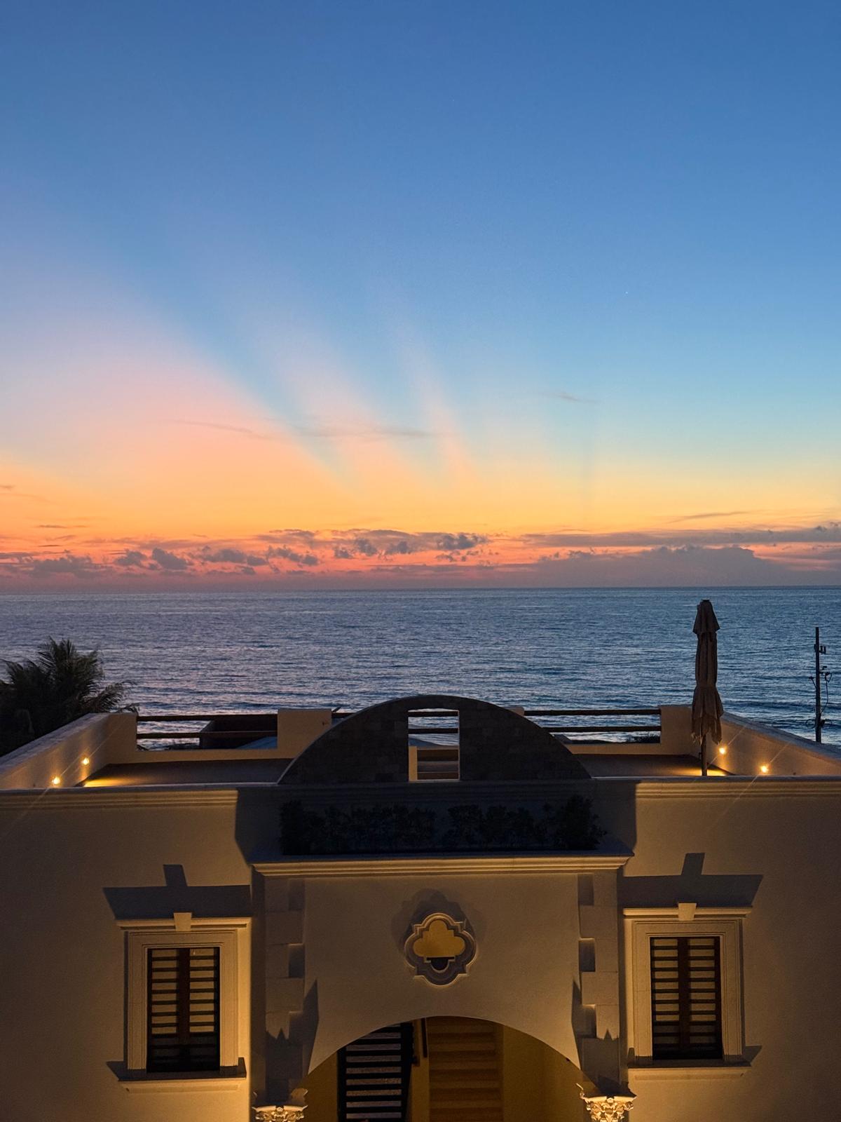 Estate facade at dusk with sunset over the sea