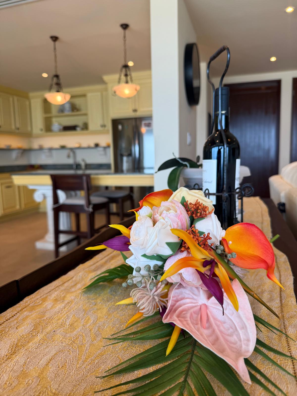 Tropical floral arrangement on the dining table with the kitchen beyond