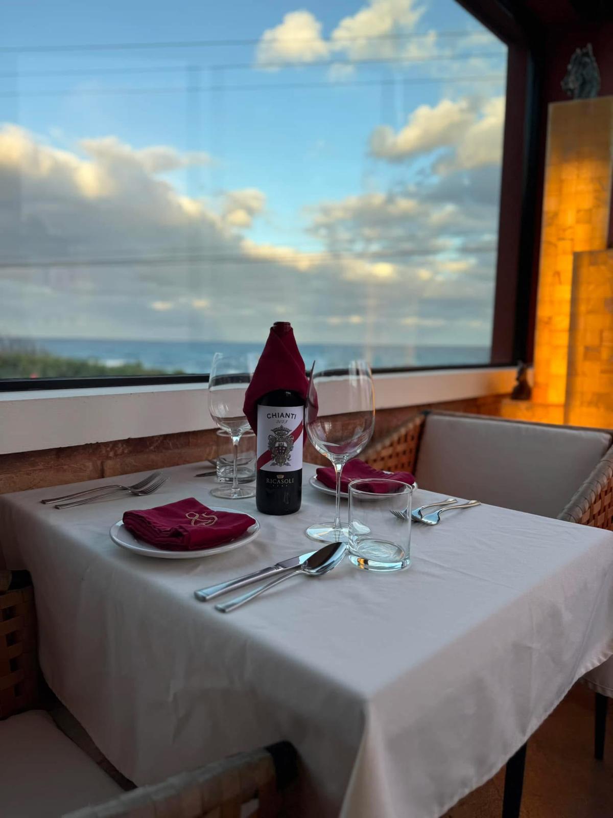 Chianti and wine glasses on a window table at sunset
