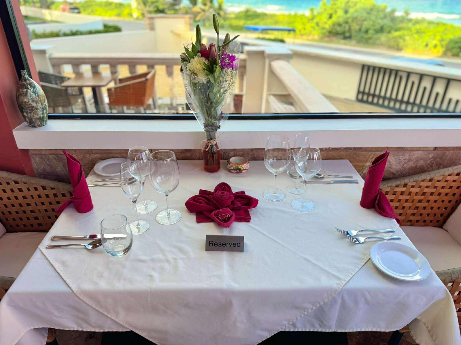 Reserved table with fresh flowers and sea view