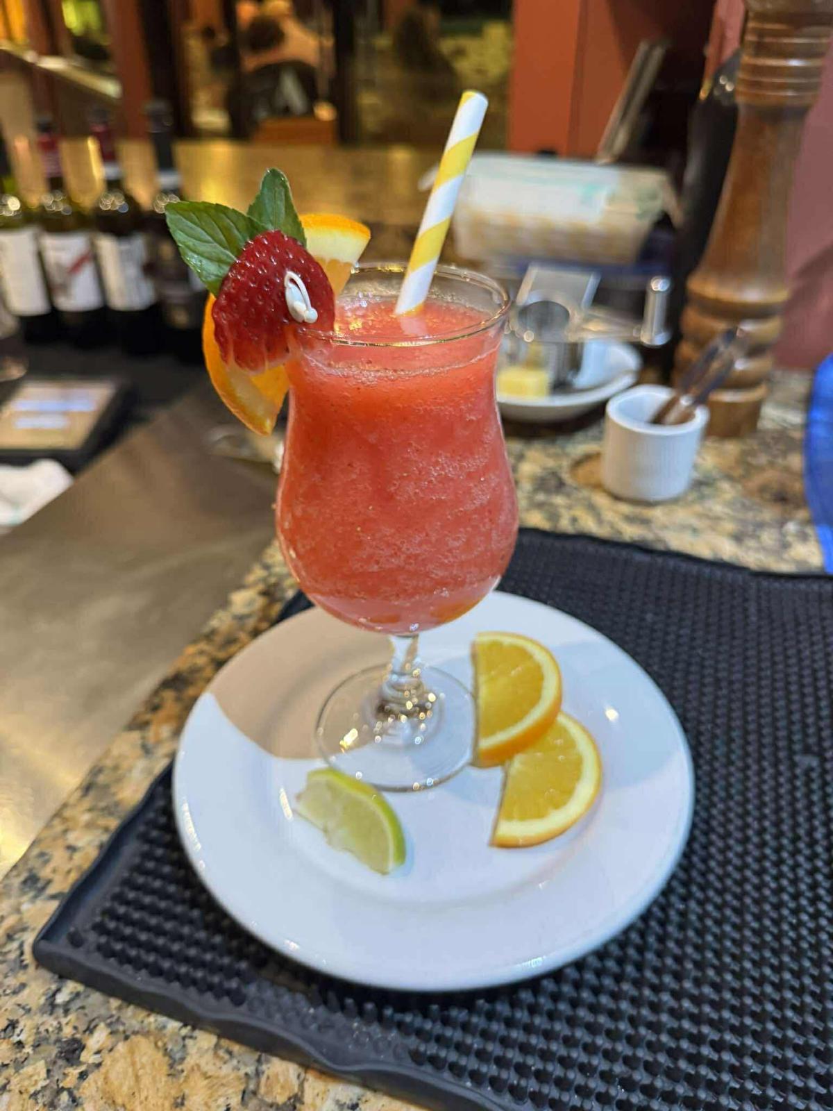 Frozen strawberry daiquiri garnished with fruit at the bar