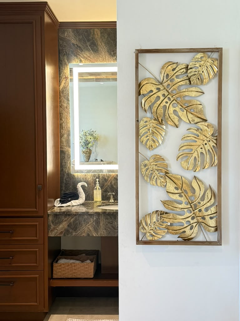 Bathroom vanity with gold monstera wall art