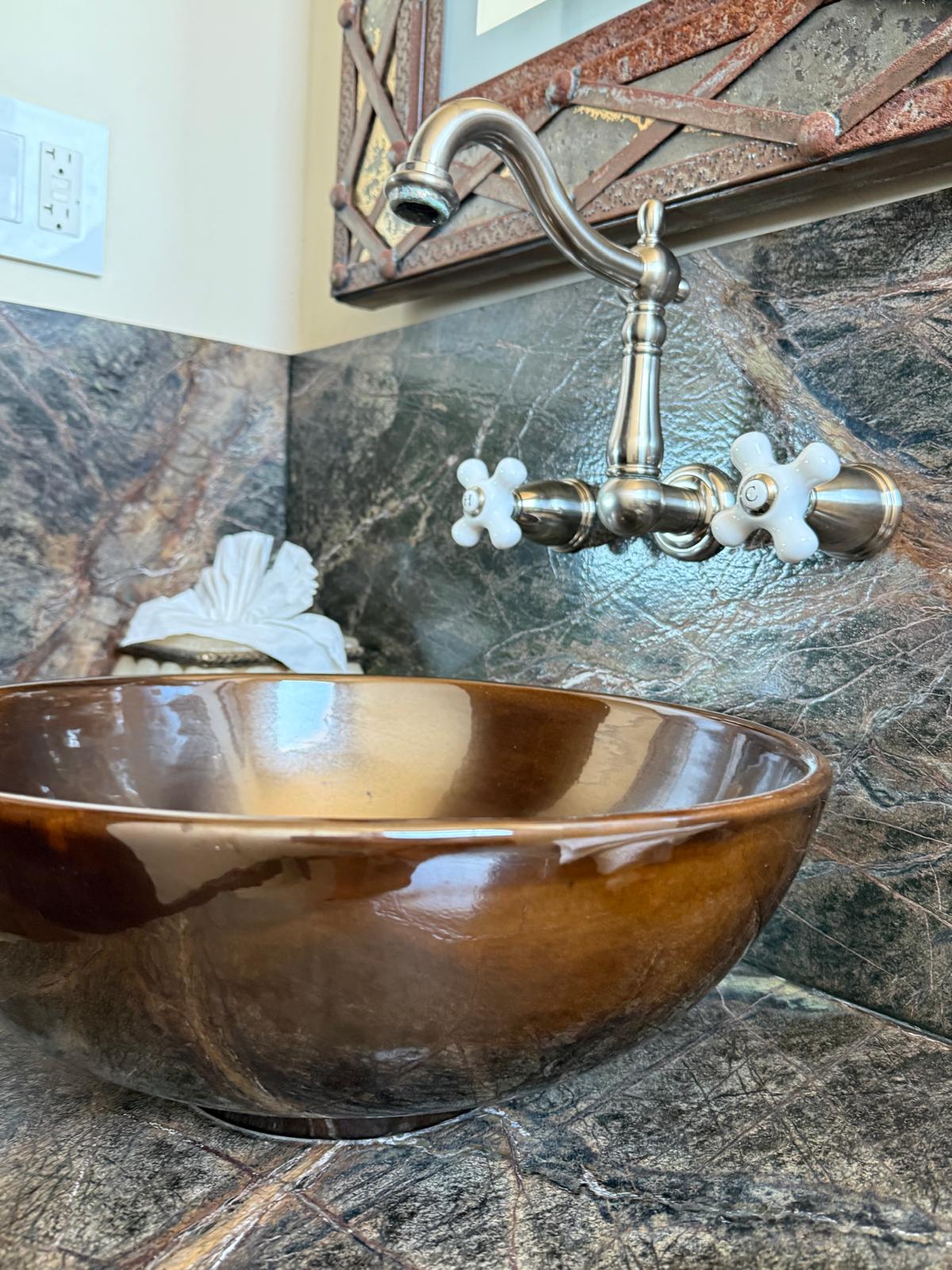 Glazed ceramic vessel sink with vintage faucet on marble counter